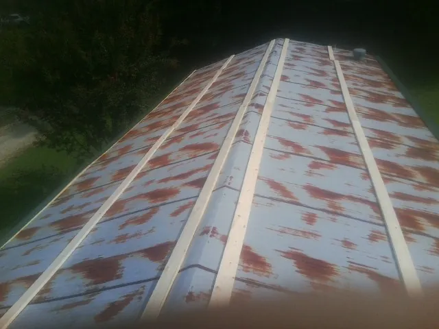 Rusted metal roof panels with new wood purlins before replacement — Storm Damage Roof Repair in Alderson by Roofing Brothers