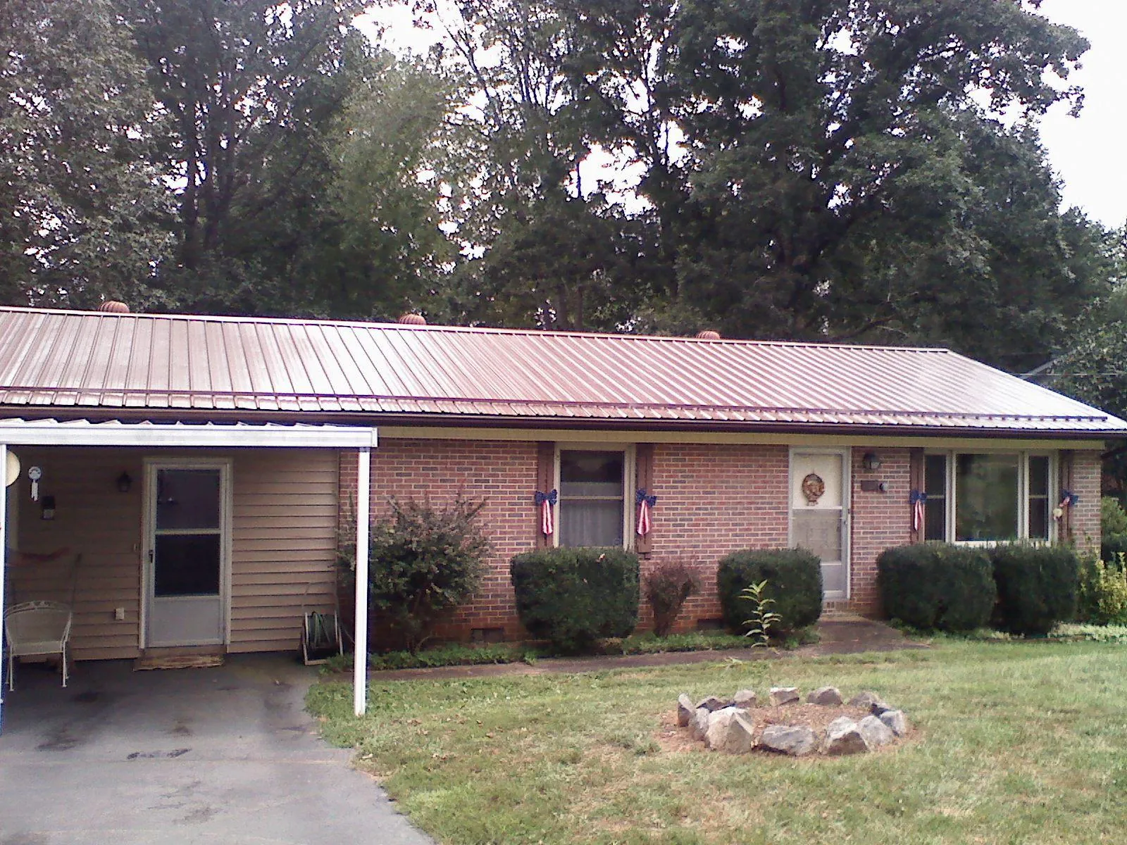 Bronze metal roof and carport on a brick ranch home — Roof Repair work by our crew in Alderson