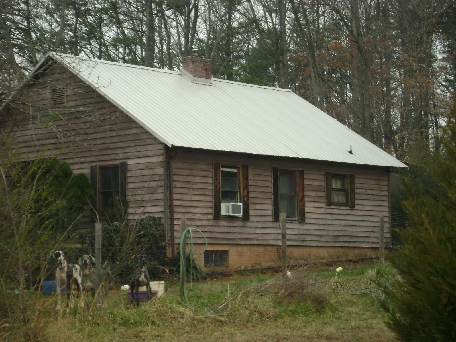White metal roof on an old wood sided farmhouse, from a Metal Roof Installation job in Alderson